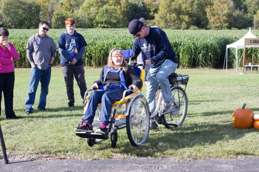 A pair of people using a wheelchair-transport bike
