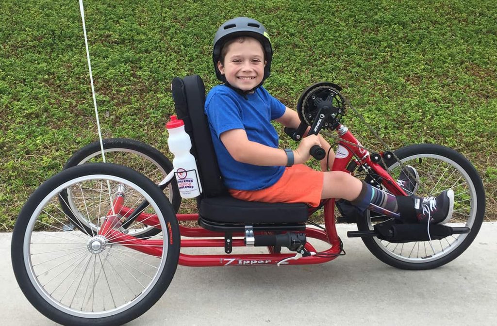 Boy using a hand-pedaled tricycle