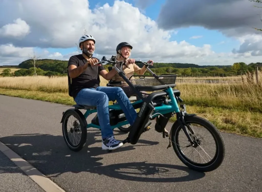 Couple riding a side-by-side tandem tricycle