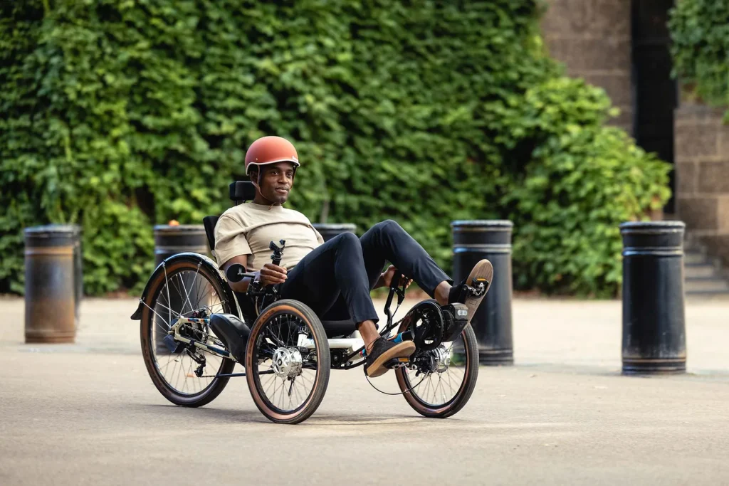 Man using a recumbent tadpole-design tricycle with two wheels in the front and one wheel in the back