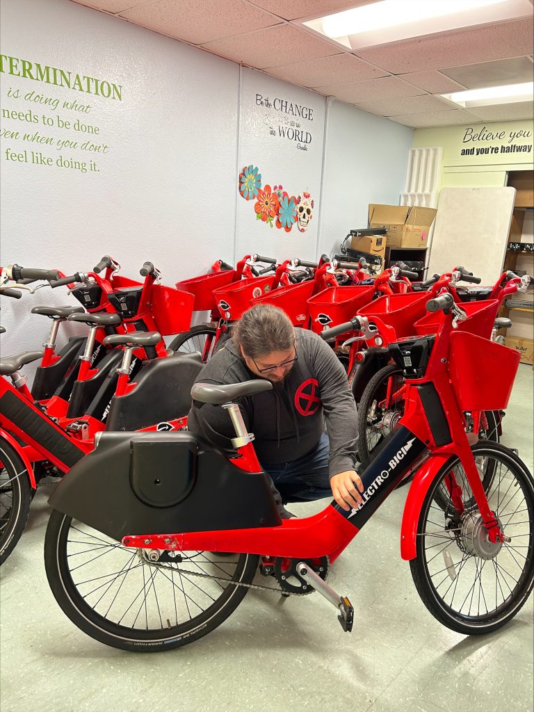 Angel, fleet mechanic, fixes an e-bike for Pacoima Beautiful's e-bike library program