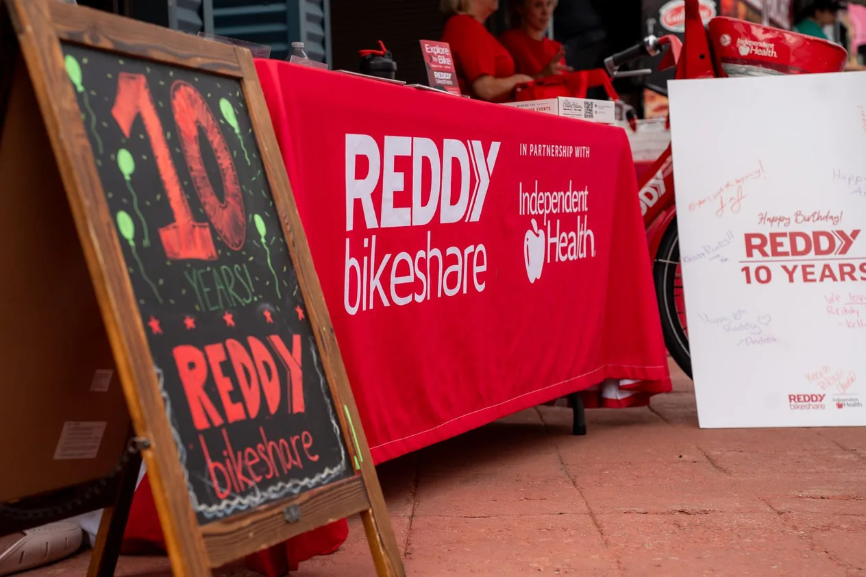 A chalkboard sign for Reddy Bikeshare's tenth birthday beside the Reddy and Independent Health table
