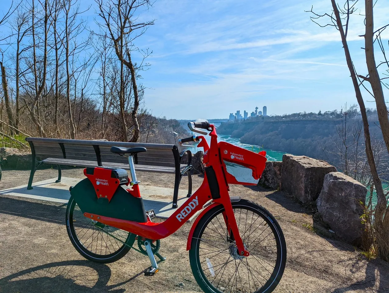 A Reddy bike at an overlook above the Niagara Gorge, with a city skyline in the distance
