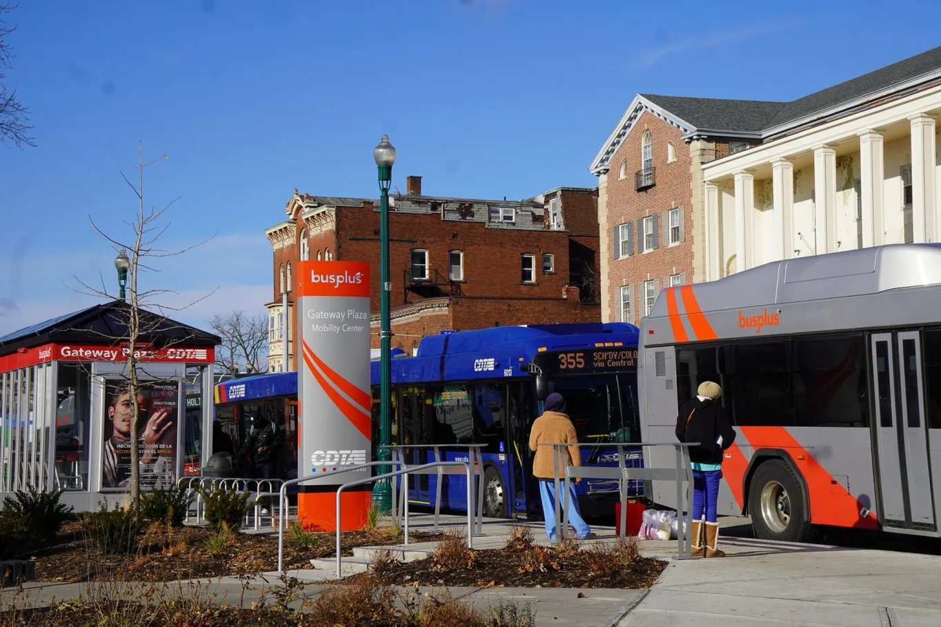 A CDTA BusPlus bus at the Gateway Plaza Mobility Center, with riders waiting at the shelter