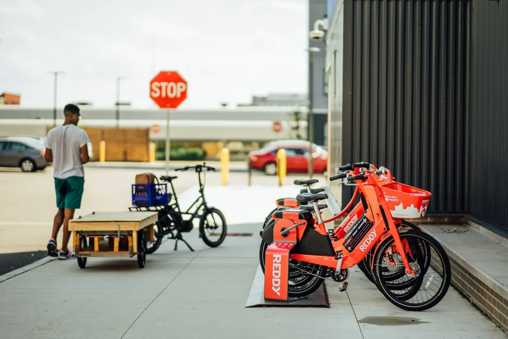 Reddy Bikeshare's Micromobility Technology Specialist Sage Welte dropping off batteries to docked bikes in downtown Buffalo.